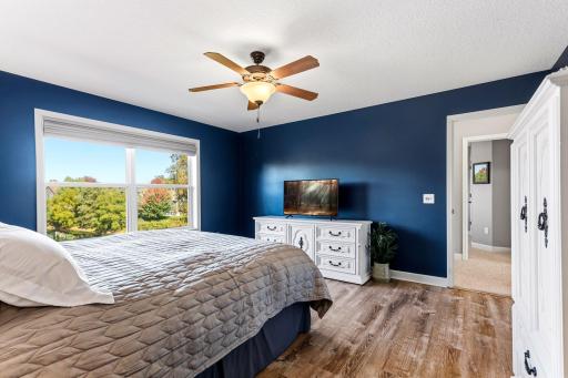 This generously sized primary bedroom accommodates large furniture pieces effortlessly while offering a seamless transition to the main hallway.