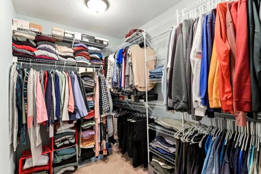 The expansive walk-in closet maximizes storage capabilities with extensive built-in shelving and multi-level hanging space to complete the suite.