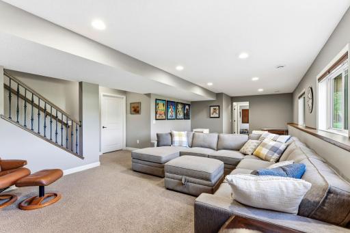 The open-concept design flows seamlessly from the staircase, which is elegantly accented by wrought-iron spindles. Crisp trim and neutral tones create a sophisticated, move-in ready entertainment space.