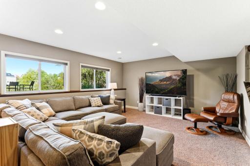Wood ledges run along the perimeter, adding architectural warmth and functional display space. The generous footprint easily accommodates large seating arrangements for modern home theater setups.