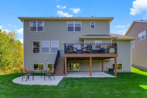A rear view highlights the impressive scale of this home's outdoor entertaining space and a scenic natural buffer.