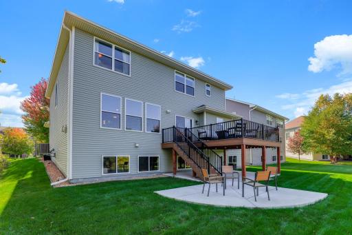 The generous backyard features a custom concrete patio, a trex deck with modern dark railings, and a lush, gently sloping lawn. Truly an ideal setup for entertaining.