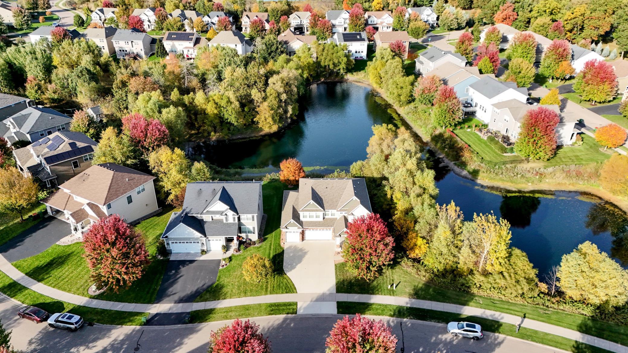 A broader perspective captures the well-maintained concrete driveway and the property's incredible proximity to the water, offering a private oasis feel.