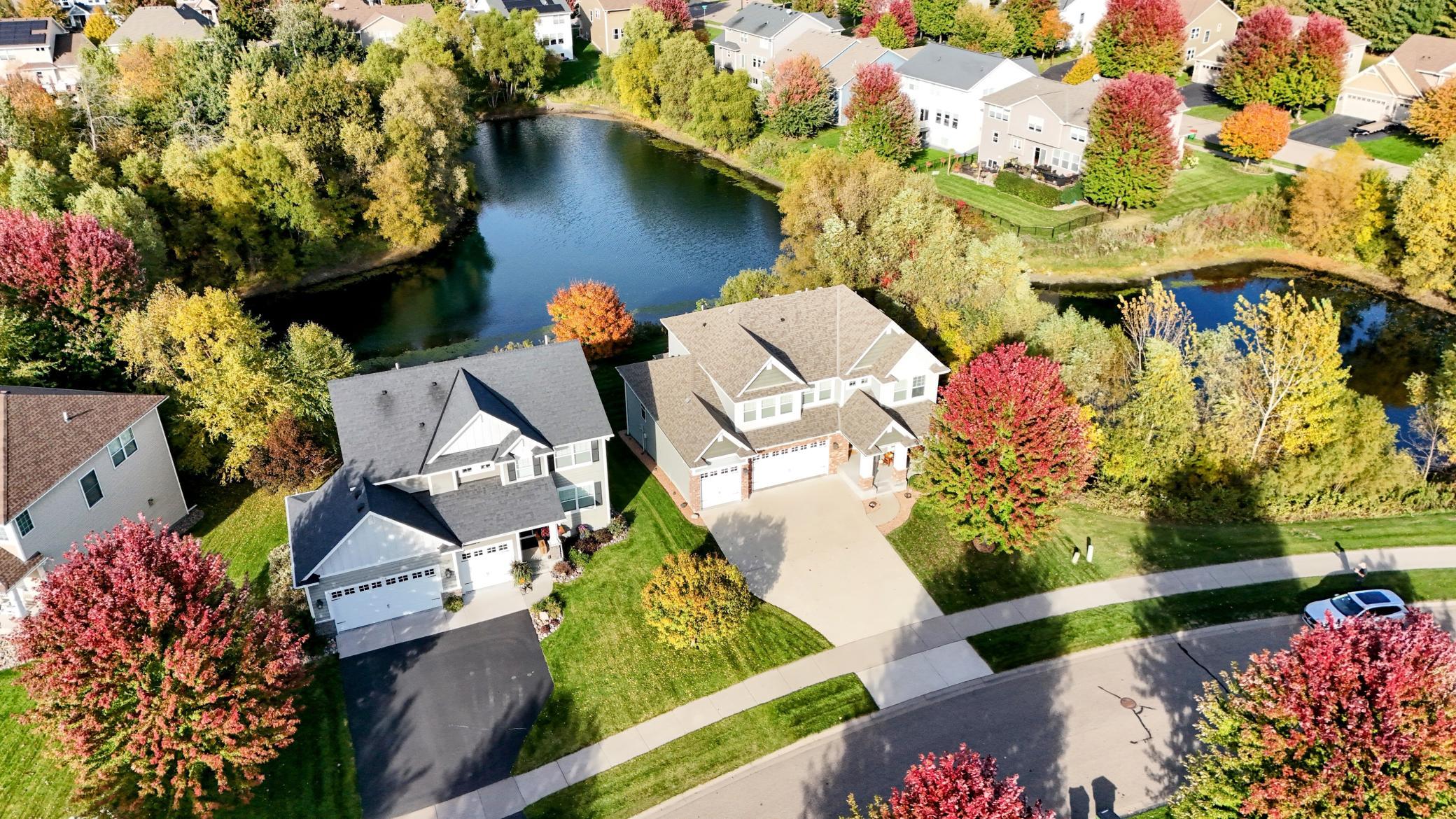 The inviting front exterior features an expansive concrete driveway and beautiful landscaping, setting the stage for this exceptional Blaine home.