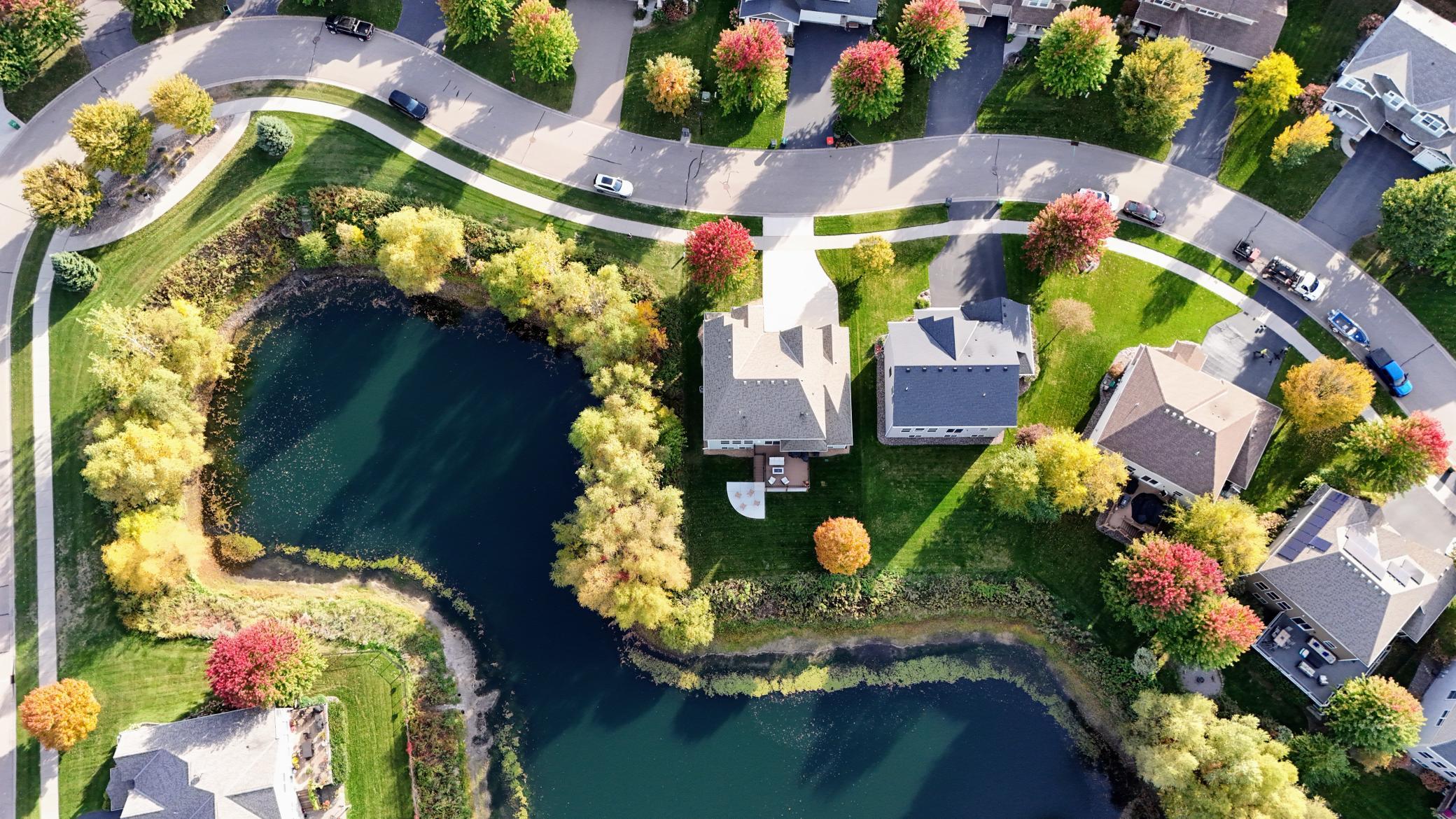 Showcasing a premium Blaine property layout, this aerial view highlights the unique placement with a serene pond wrapping around two sides of the home.