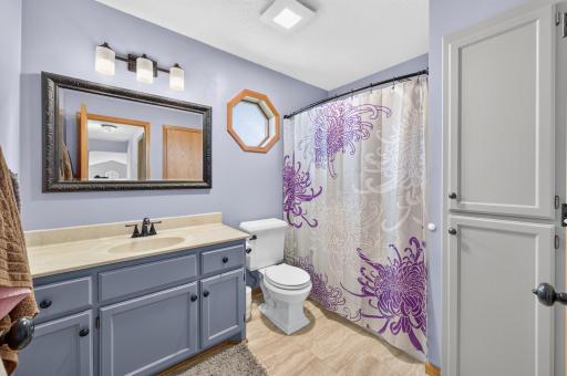 Upper-level full bath featuring ample vanity storage, updated fixtures, and additional built-in storage.
