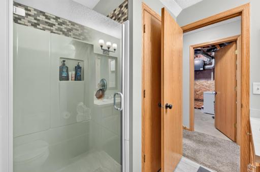 Lower-level full bath featuring a walk-in shower and convenient access to the potential primary suite.