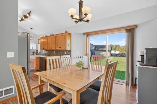 Spacious dining area with vaulted ceiling, abundant natural light, and sliding glass door leading to the backyard.