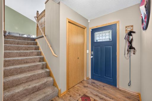 Welcoming entryway with updated flooring and convenient coat closet.