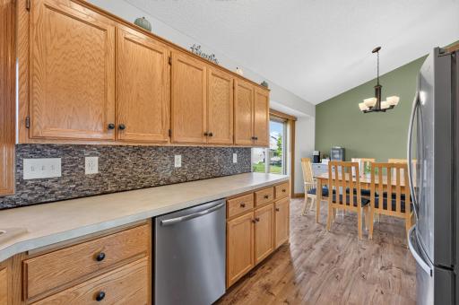 Generous kitchen cabinetry and counter space flow seamlessly into the bright dining area.