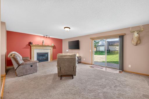 Spacious main-level family room featuring a cozy gas fireplace and sliding glass door with easy access to the backyard.