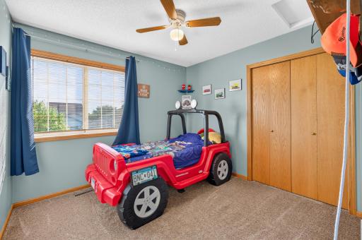 Third upper-level bedroom featuring a ceiling fan, generous closet space, with large window and abundant natural light.