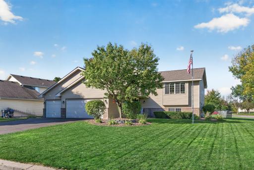 Impressive curb appeal with a beautifully manicured lawn, mature landscaping, and spacious three-car garage.
