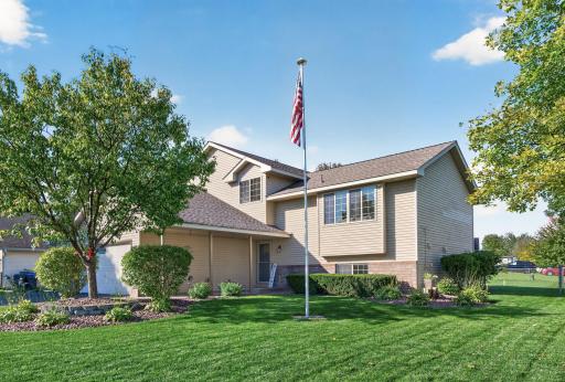 Beautifully maintained exterior with mature trees, lush landscaping, and a welcoming front entrance.
