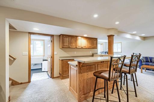 Lower level wet bar/kitchenette with laundry to the left and walkout to the patio on the right