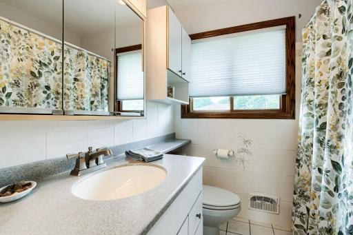 Main floor full bath with new solid surface counter & ceramic floors & walls
