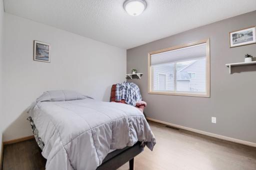 Spacious main-level bedroom featuring a large window that fills the room with natural light. A comfortable and versatile space for guests, a home office, or everyday living.