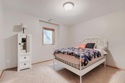 Lower-level fifth bedroom offers a comfortable and private space with plenty of room for furnishings. A great option for guests or additional living space.