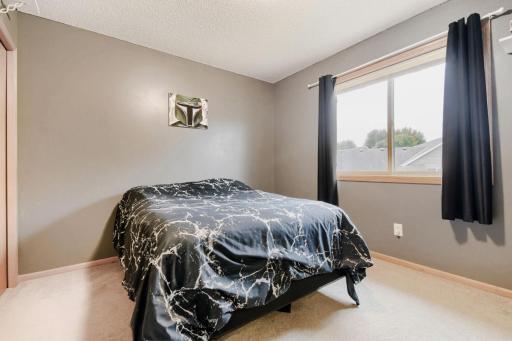 Comfortable second-floor bedroom featuring a spacious layout and plenty of natural light. A large window creates a bright and welcoming feel.