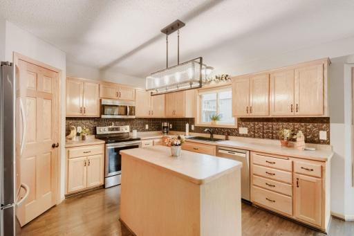 Another view of the spacious kitchen highlights the center island, abundant cabinetry, and generous counter space. Stainless steel appliances and an open design create a functional and inviting space for cooking and gathering.