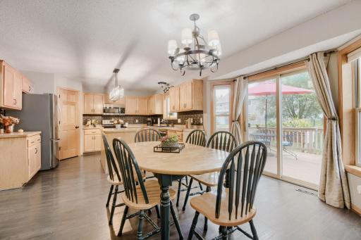 Informal dining area flows seamlessly into the open kitchen, creating a comfortable space for everyday meals and entertaining. Sliding glass doors provide easy access to the outdoor deck and bring in plenty of natural light.