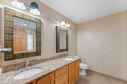 Primary bedroom's ensuite bathroom features double vanity.
