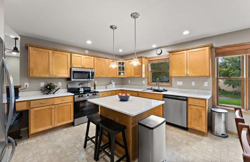 Updated kitchen featuring quartz counters and stainless steel appliances