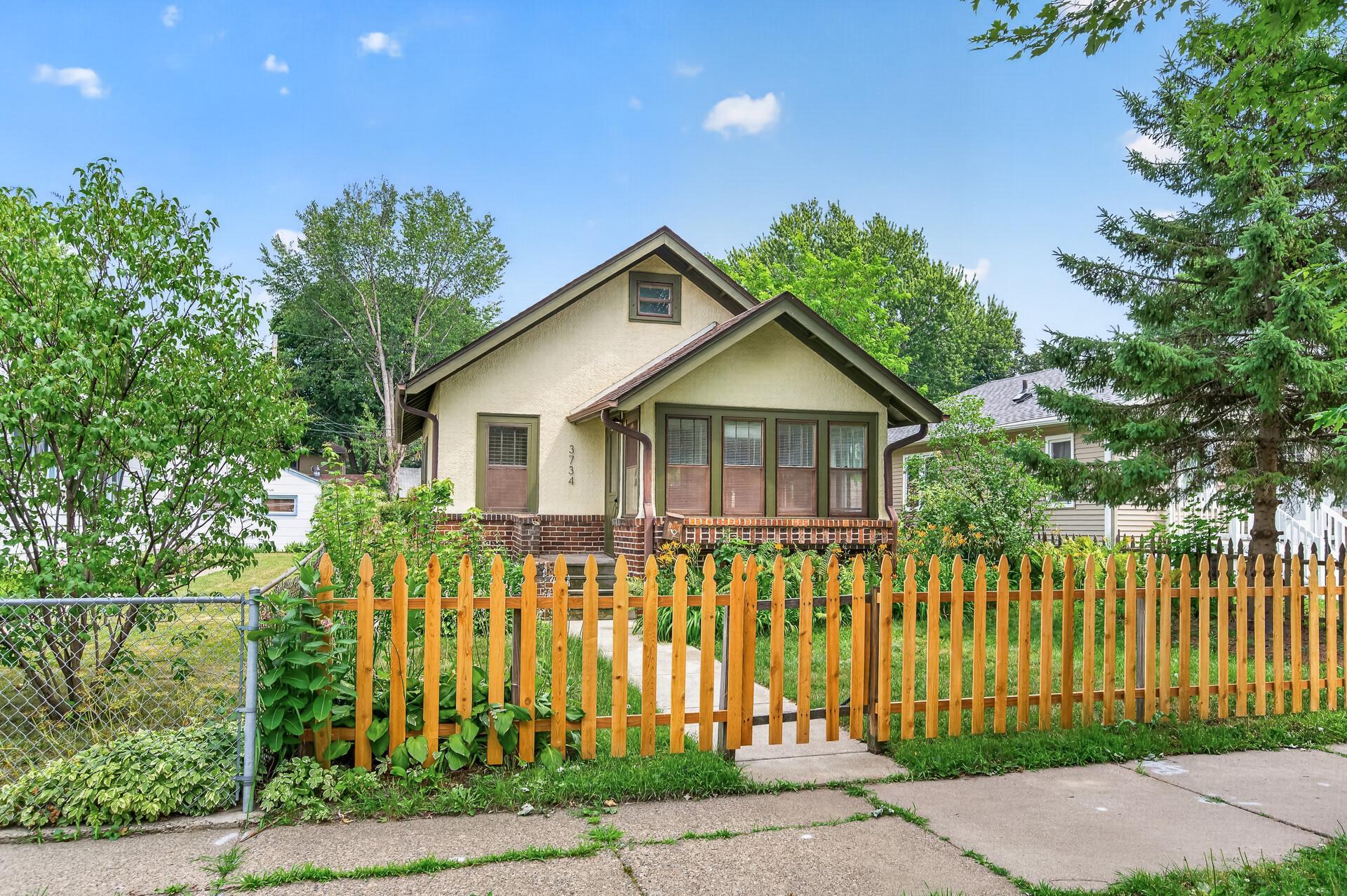 Charming front exterior with welcoming picket fence