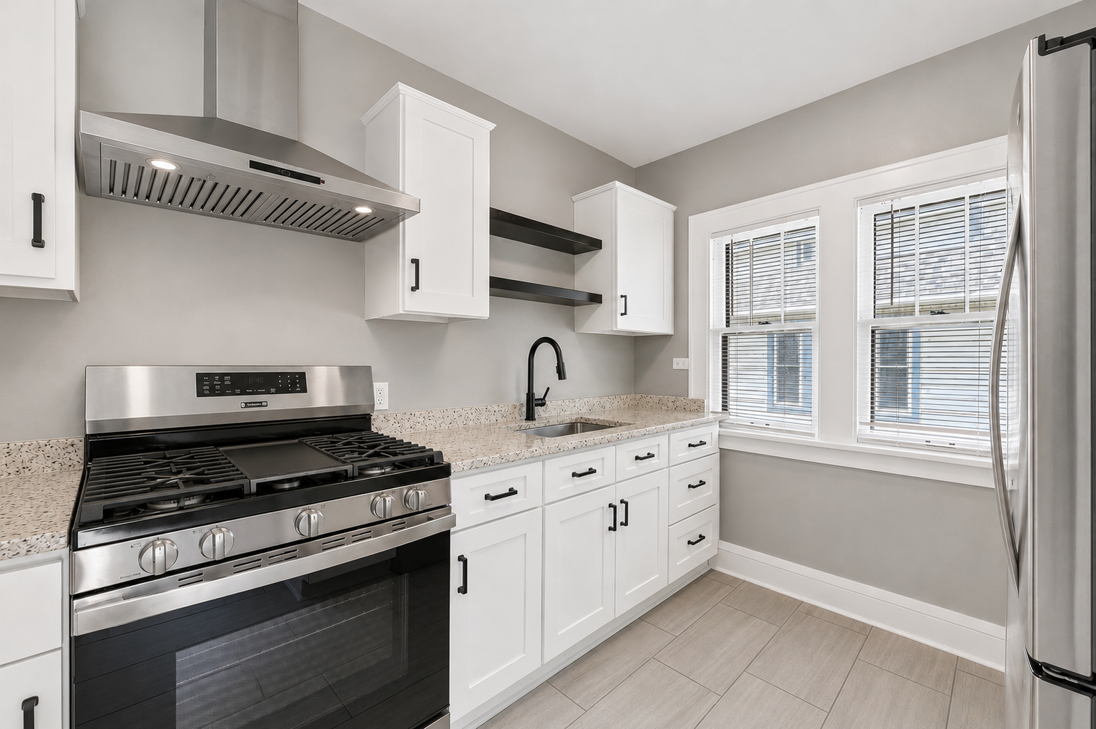 Updated kitchen with white cabinetry and stainless steel appliances
