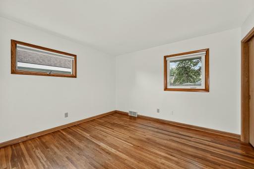 Main floor bedroom with closet and hardwood flooring.