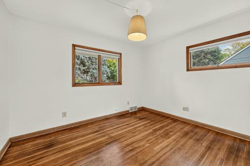 Main floor bedroom with hardwood flooring.