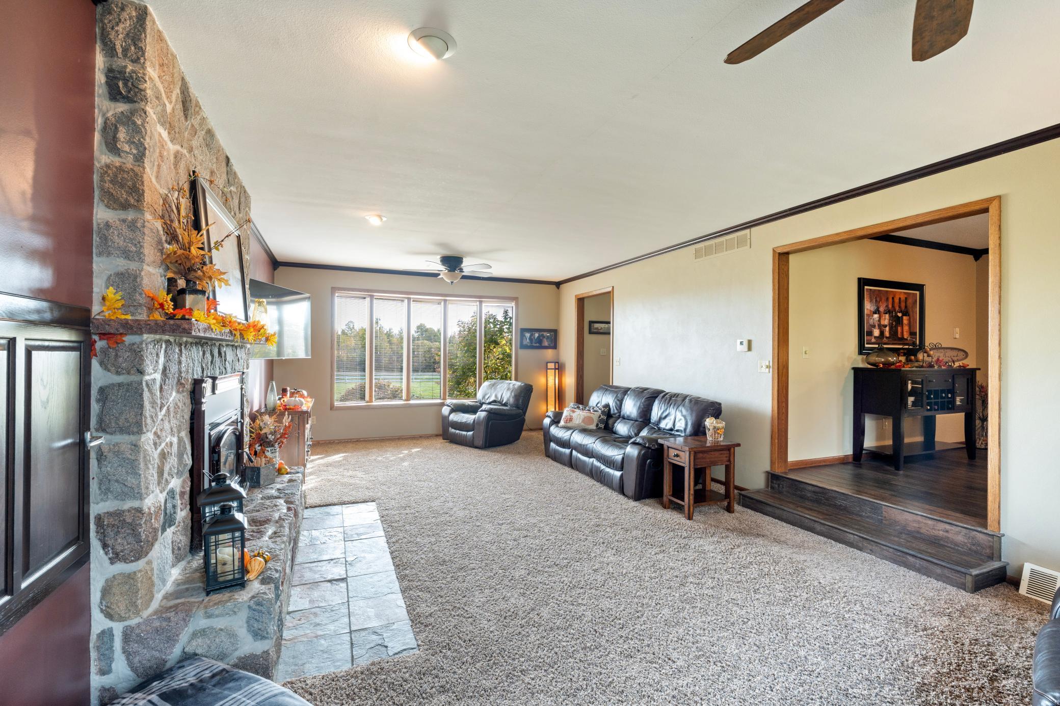 Living room with stone fire place off dining room