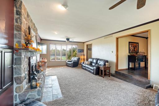 Living room with stone fire place off dining room