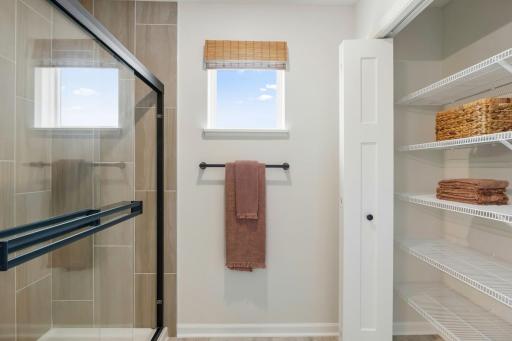 Primary bath with large tiled shower and exceptionally spacious linen closet for all the essentials.