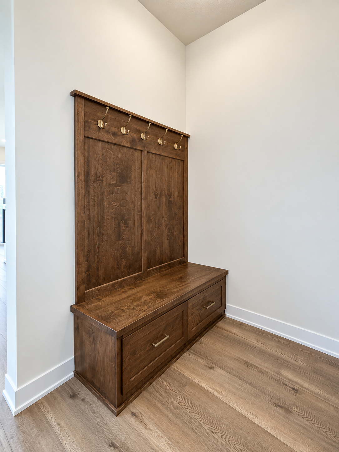 Dedicated mudroom featuring a custom built-in bench with storage, paneled detail, and convenient hooks for everyday organization.