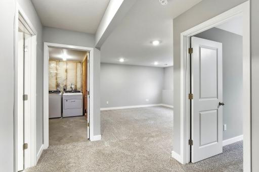 Lower level family room, with view of utility/laundry space and 4th bedroom