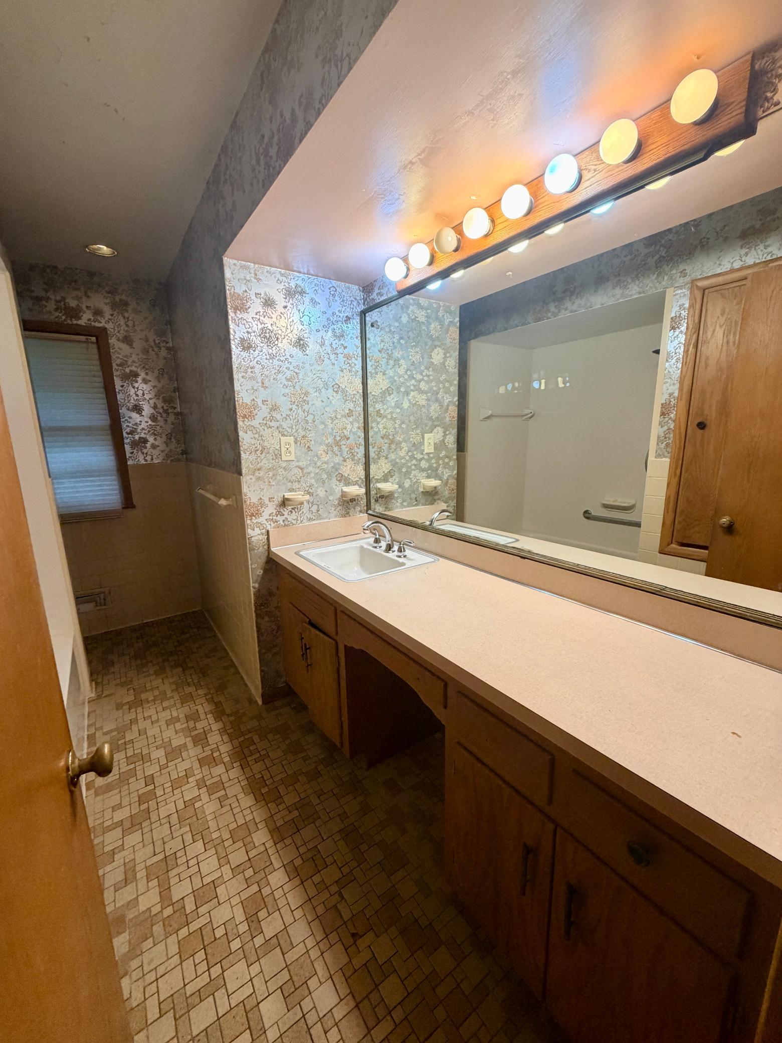 The main level full bath features an extra wide vanity with ample space for a second sink and a full-sized alcove tub.