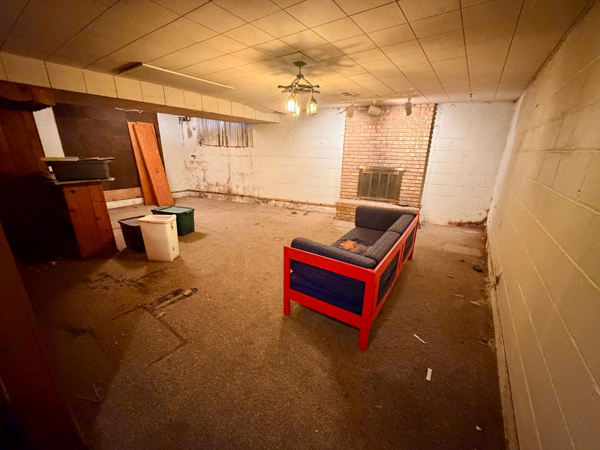 The basement family room is ready for your personal touches. An authentic period woodburning fireplace is a focal point of the room. Mold is present.