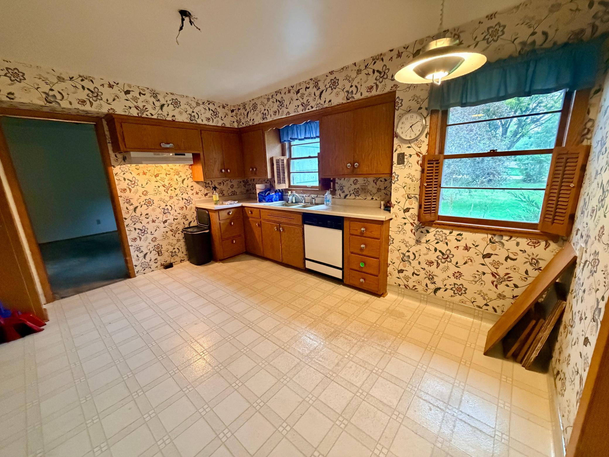 The rectangular, eat-in kitchen overlooks the private back yard and can accommodate a small breakfast or cafe table. The range and refrigerator have been removed.