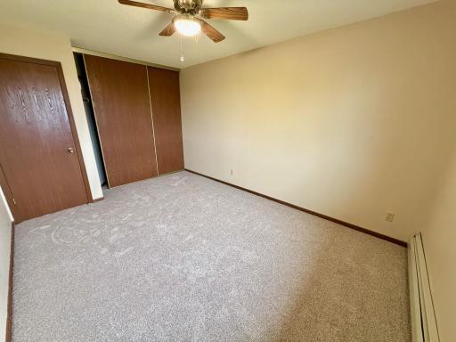 Guest bedroom with fresh paint new carpet ceiling fan.jpg