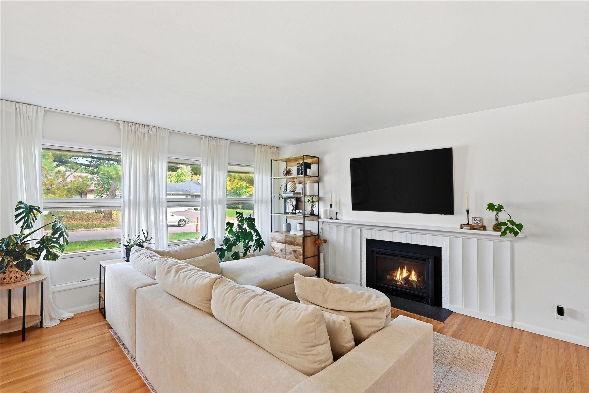 Living room light and bright with gas fireplace and real hardwood floor throughout the home!