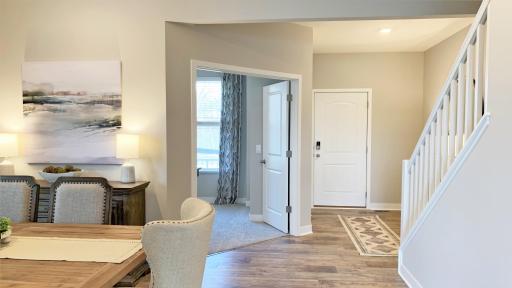 Charming foyer view with open rail staircase and in home office/study with double doors. Photo of model home, colors and finishes vary.