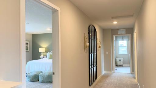 Upper-level view of spacious walkway, primary suite and upper-level laundry - on the same level as all bedrooms. Photo of model home, colors and finishes vary.