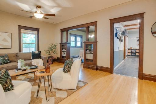 Large living room with built ins, original hardwood floors, and woodwork