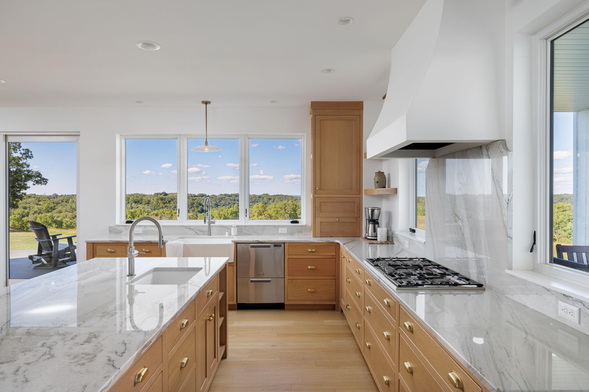 9 Chef's Kitchen with Thermador Gas Cooktop, Custom Hood, & Expansive Windows.jpg