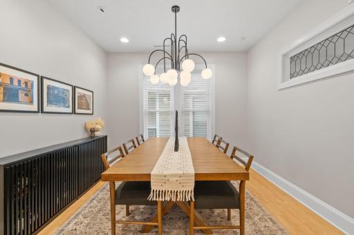 Separate dining room with chic lighting and leaded glass accent window