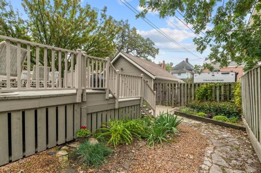 Deck area and walking path to detached garage. The condo includes 1 indoor garage parking stall (East side) and 1 dedicated outside parking space on concrete slab (West side of garage). Free street parking is available for guests.