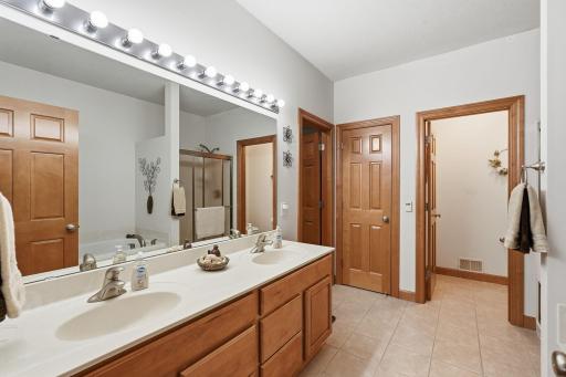 Primary bath features dual sinks, separate shower, and soaking tub.