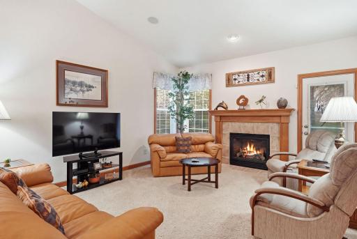 Spacious living room highlighted by a gas fireplace, vaulted ceiling, and abundant natural light.