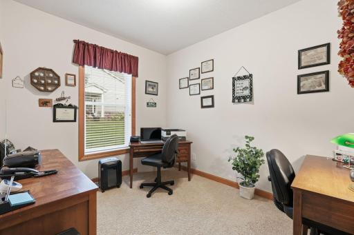 Main level den offers flexible space for a home office, study, or hobby room.